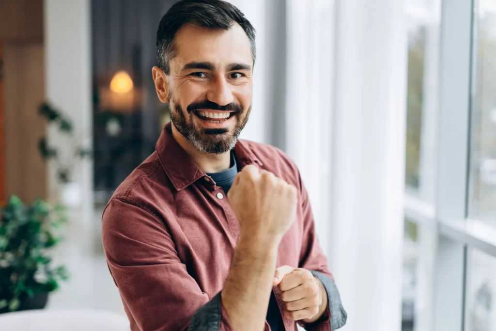 smiling adult man poses indoors near bright window utc ()